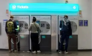 Personas comprando tickets en máquinas automáticas en París.