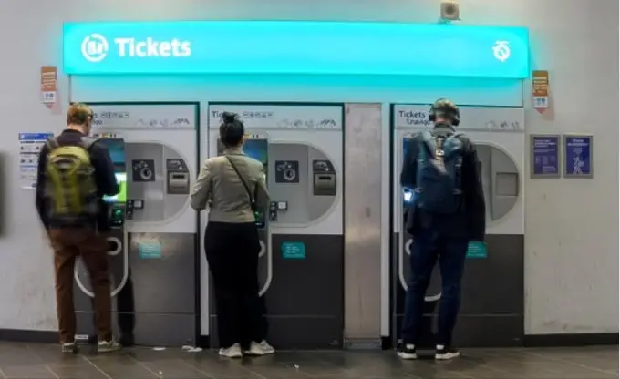 Personas comprando tickets en máquinas automáticas en París.