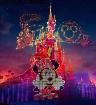 Minnie y castillo iluminado en Disneyland Paris por la noche.