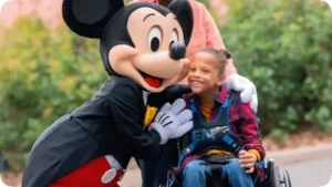 Mickey con una niña con Pase Prioritario Disneyland París